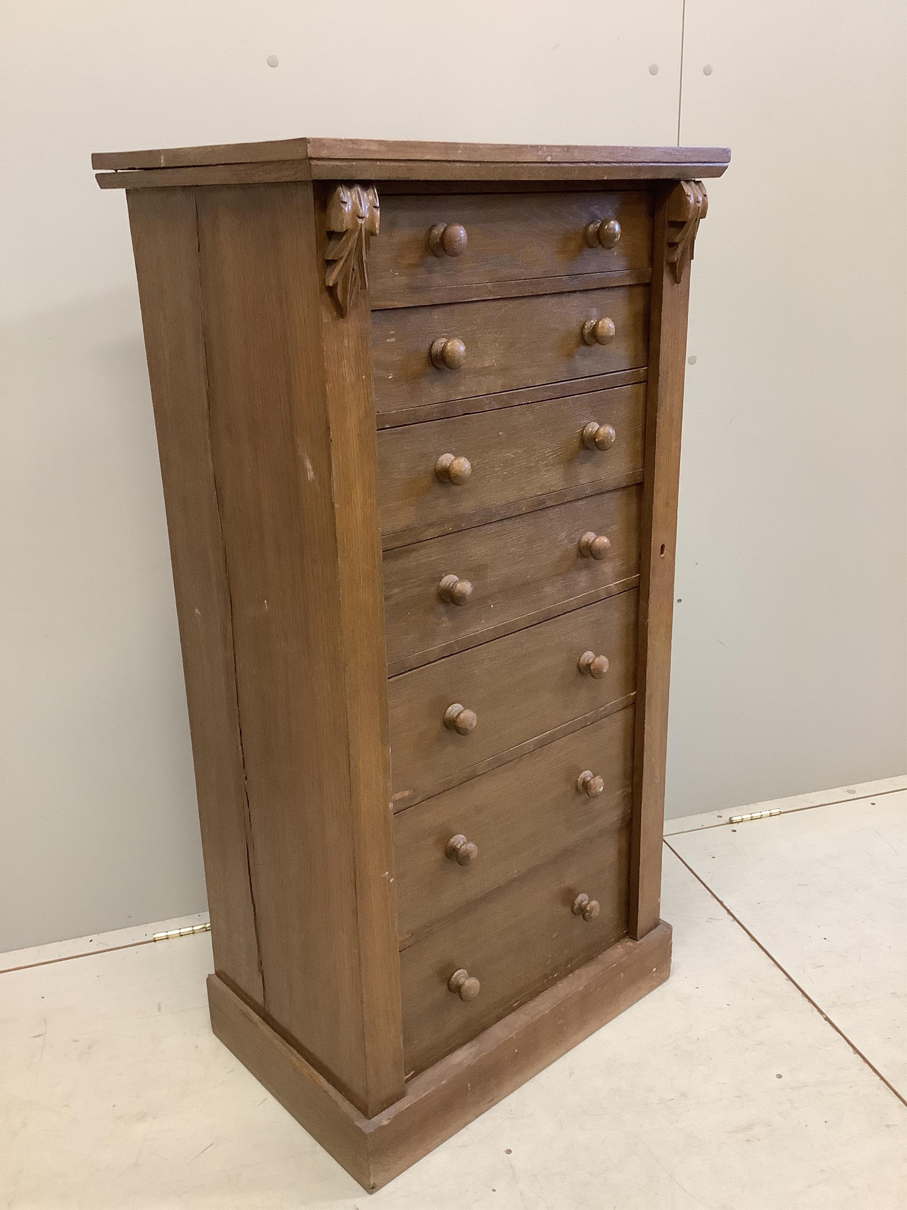 A Victorian style oak Wellington chest, width 60cm, depth 42cm, height 120cm. Condition - fair, top has a horizontal split, plinth foot scuffed and worn.